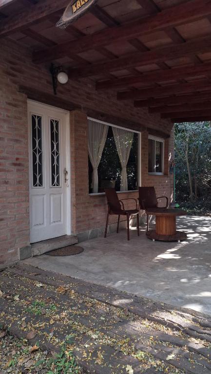 a patio with chairs and a table and a white door at Complejo Tiú Mayú in La Granja