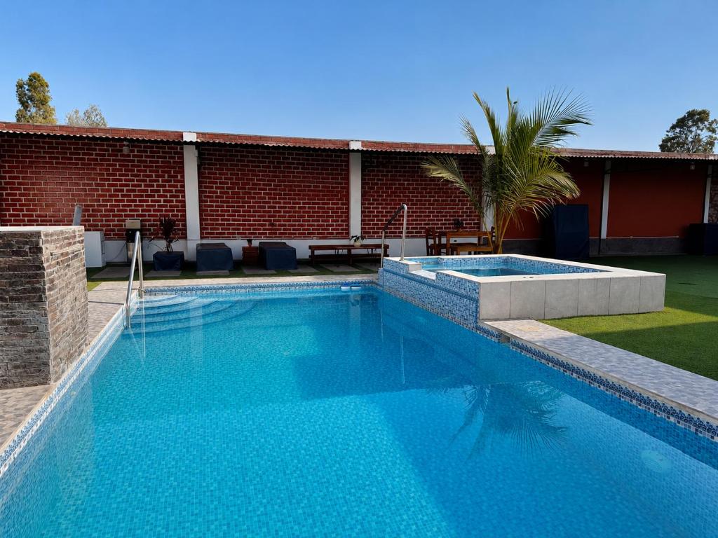 a swimming pool in front of a brick building at Búnker de Coco in Pachacamac