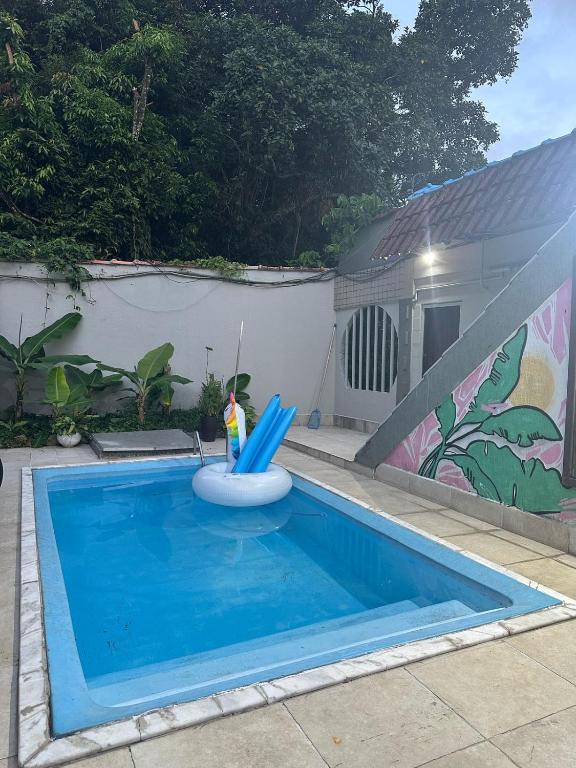 a toy figurine sitting on a inflatable raft in a swimming pool at Coffehouse - Casa com Piscina in São Vicente