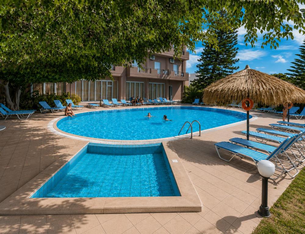 a large swimming pool with chairs and people in it at Castro Hotel in Amoudara Herakliou