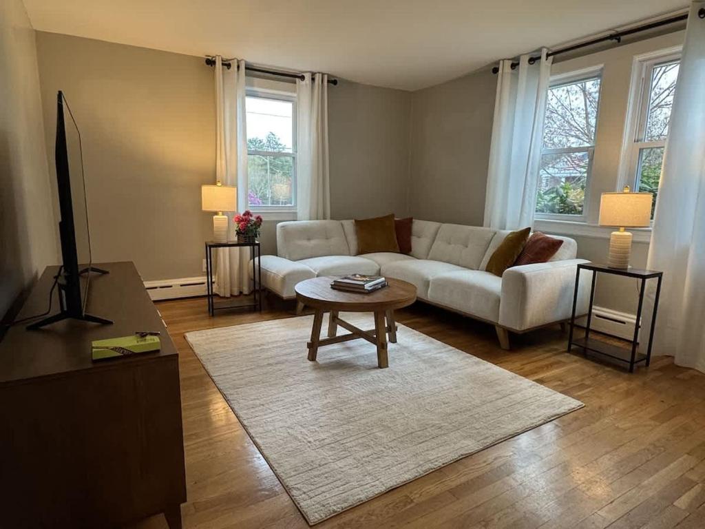 a living room with a couch and a table at Comfortable 4 Bed Home close to Gillette in Foxborough
