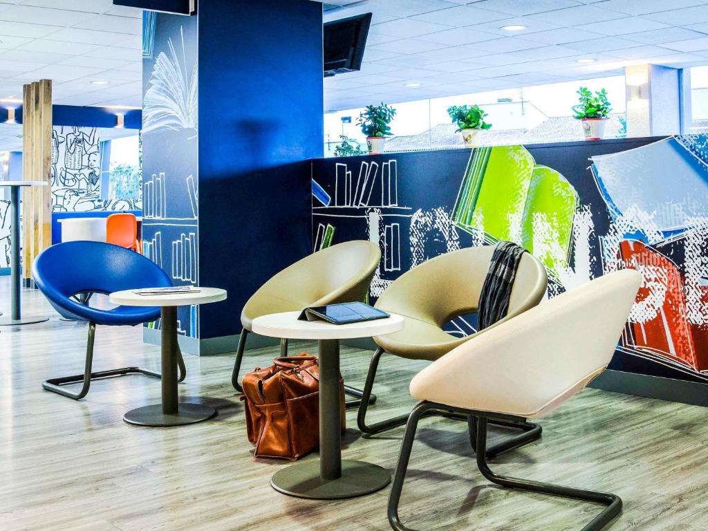 a group of chairs and tables in a room at Ibis Budget Fréjus St Raphaël centre plages gare TGV in Fréjus