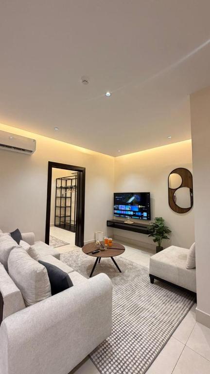 a living room with two couches and a tv at نُزل البدر - غرفة و صالة دخول ذاتي in Al Kharj