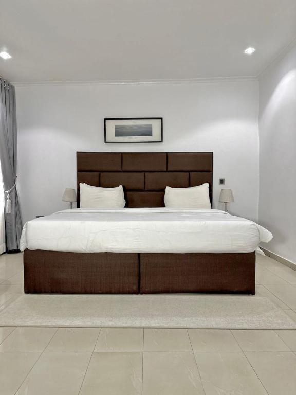 a bedroom with a large bed with a wooden headboard at ModexD'Crib in Lagos
