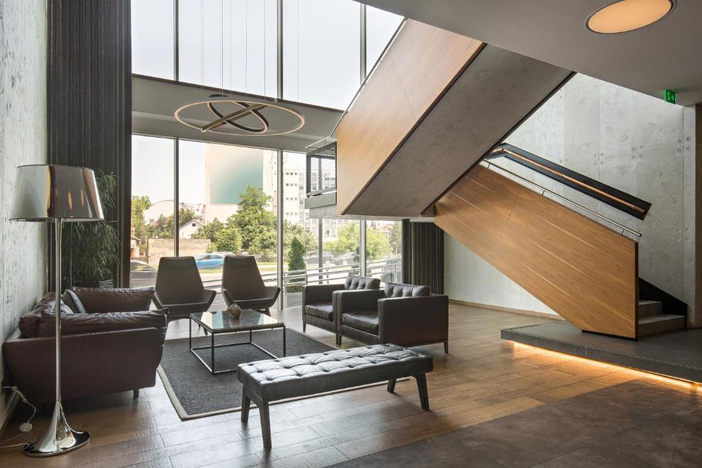 a living room with a couch and a staircase at Sheraton Novi Sad in Novi Sad