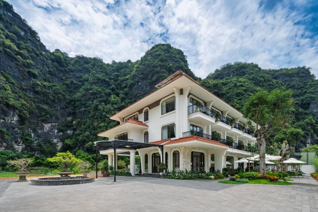 a hotel with mountains in the background at Heritage Charm Hotel Trang An in Ninh Binh