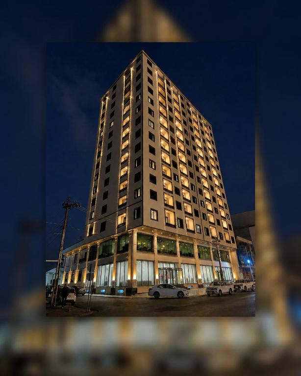 a tall building with cars parked in front of it at MyFlower 3 Hotel in Erbil