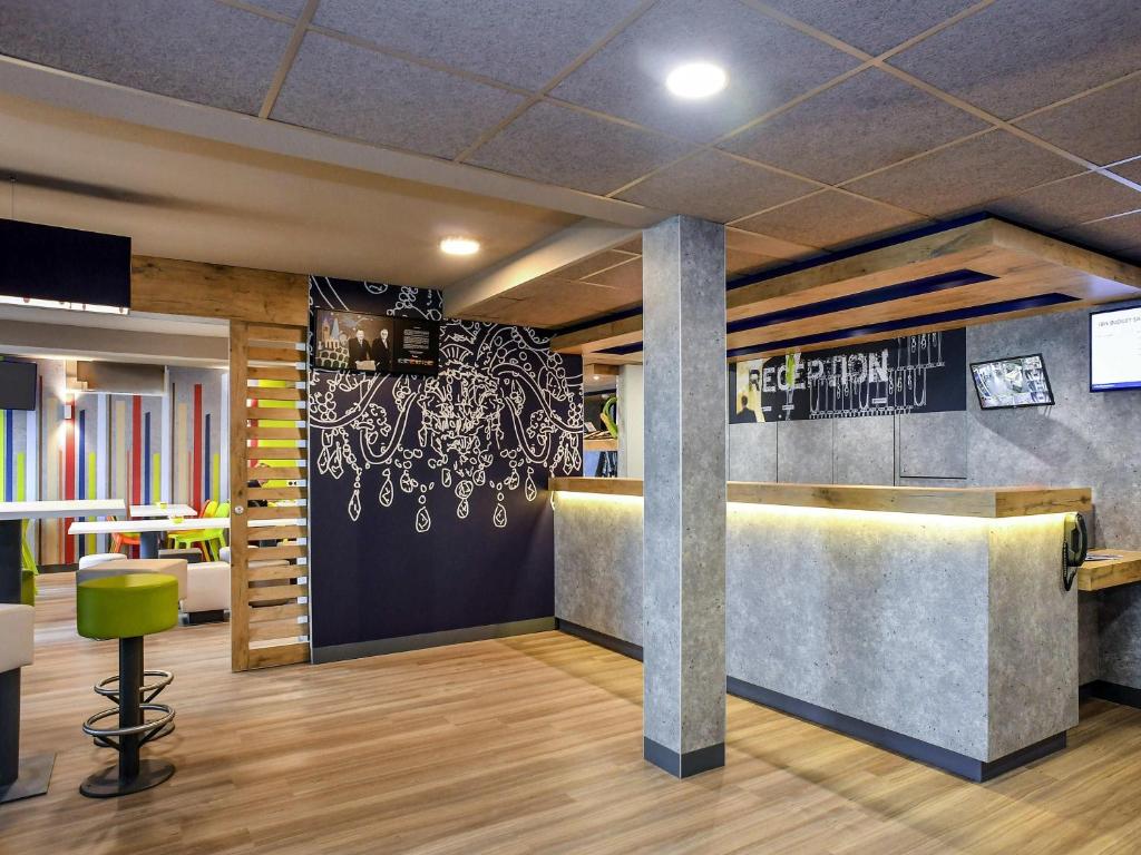 a lobby of a restaurant with a barber shop at ibis budget Coutances in Coutances