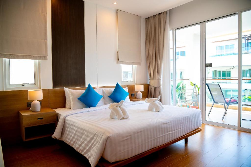 a bedroom with a large bed with blue and white pillows at Krabi One Bedroom Pool View in Klong Muang Beach