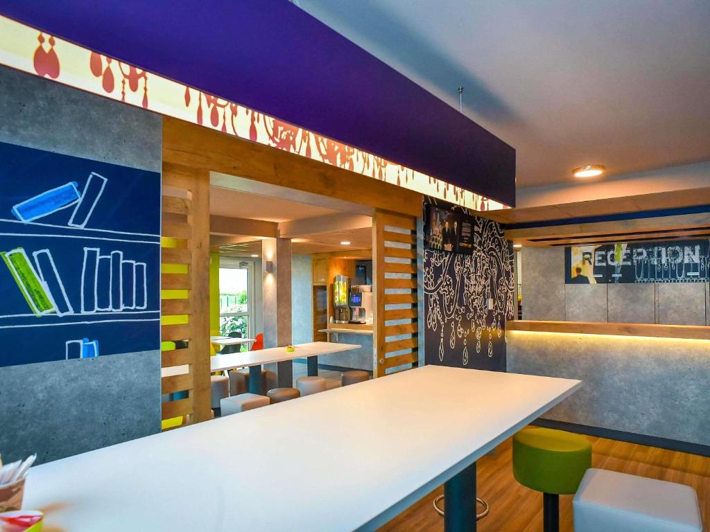 a restaurant with a white table and chairs at ibis budget Saint Lô in Saint Lo