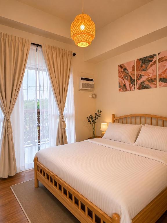 a bedroom with a large bed and a window at Boho-Nordic Studio at Twin Lakes Vineyard, Tagaytay by Cozy Escape in Laurel