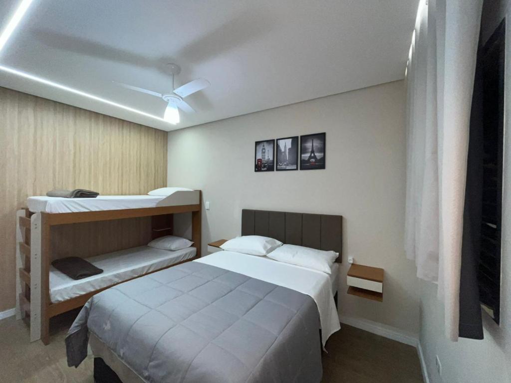 a bedroom with a bed and a bunk bed at Hostel Pouso Gru - Translado Aeroporto Gru grátis in Guarulhos