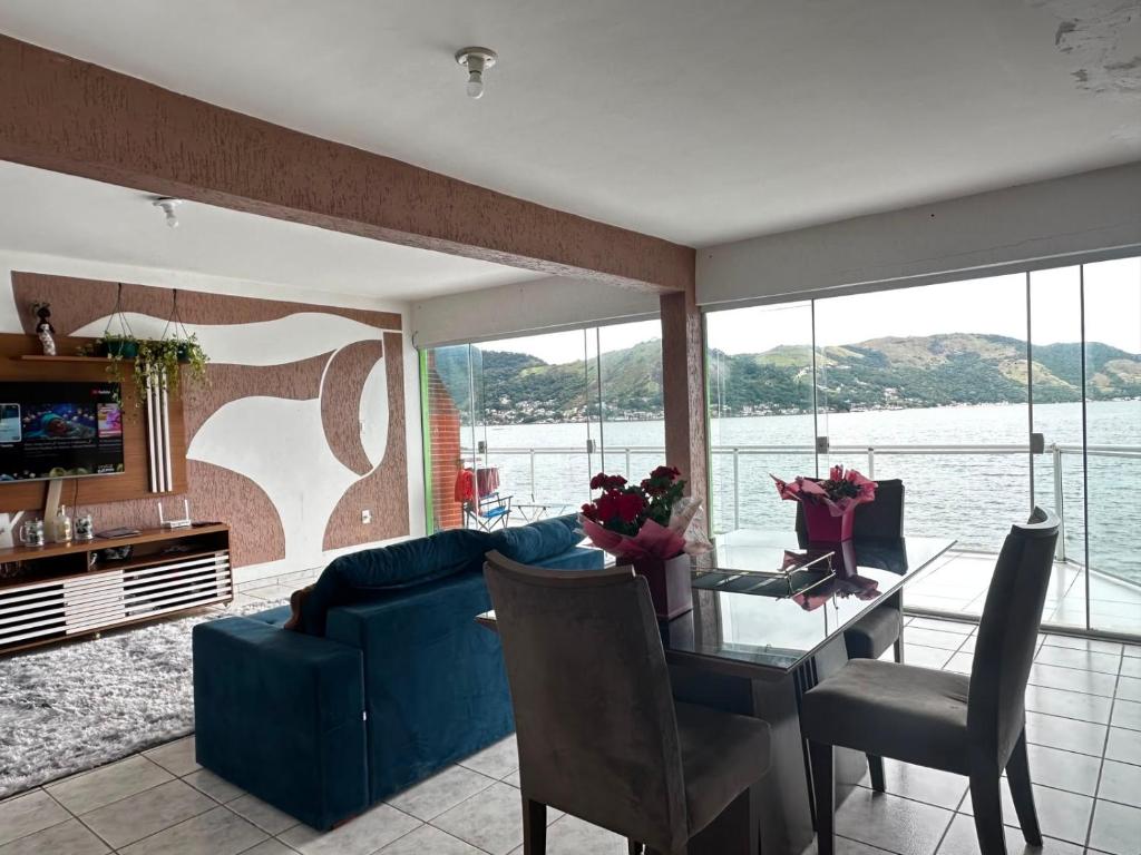 a living room with a blue couch and a table at Meneghetti Mangaratiba in Mangaratiba
