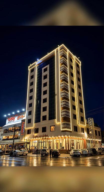 a large building with cars parked in a parking lot at MyFlower 1 Hotel in Erbil