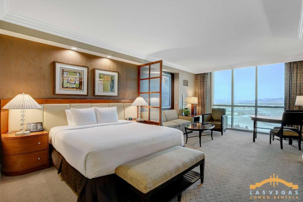 a bedroom with a large bed and a living room at Deluxe Spa 24th floor Signature Studio with Mountain View in Las Vegas