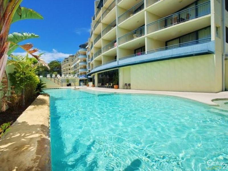 a large swimming pool next to a building at Casablanca Penthouse Loft - Landmark 518 in Nelson Bay