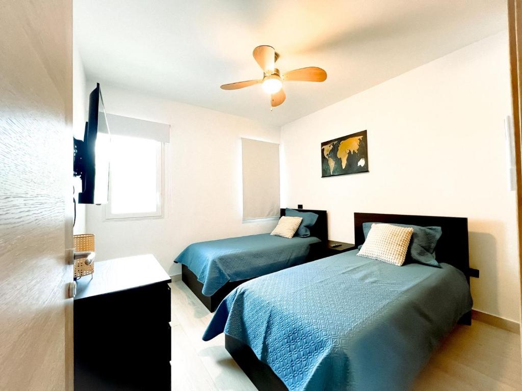 a bedroom with two beds and a ceiling fan at Estrella Garden Condos con Vista a la piscina in San Rafael del Yuma