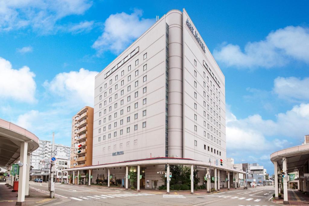 a large white building on a city street at Art Hotel Joetsu in Joetsu