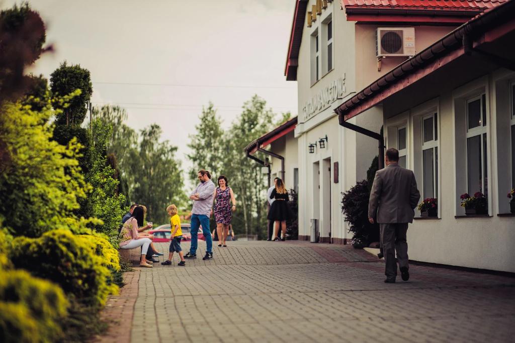 un grupo de personas caminando por una calle en Laura, en Bełchatów