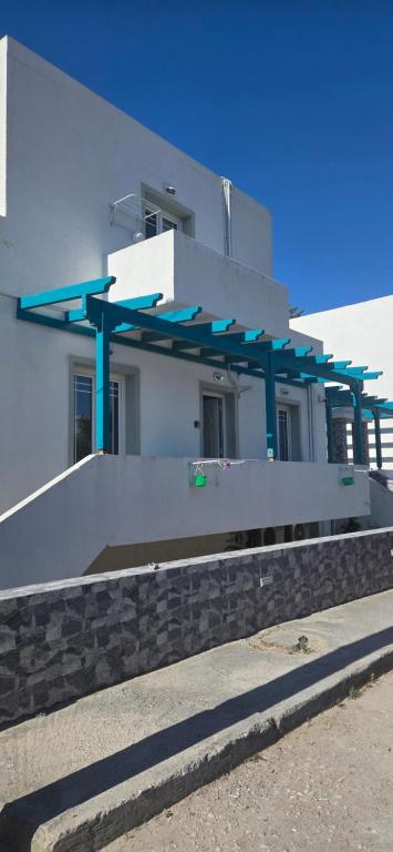 a white building with blue supports on the side of it at Alegrias spot in Adamantas