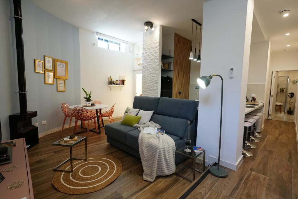 a living room with a blue couch and a table at Zen Loft Quiet Retreat near St julians in Is-Swieqi