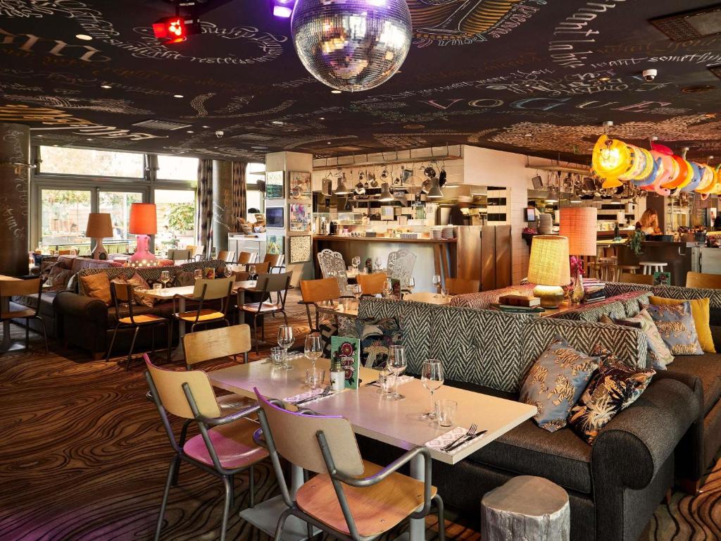 a restaurant with tables and chairs and a bar at Mama Shelter Lyon in Lyon