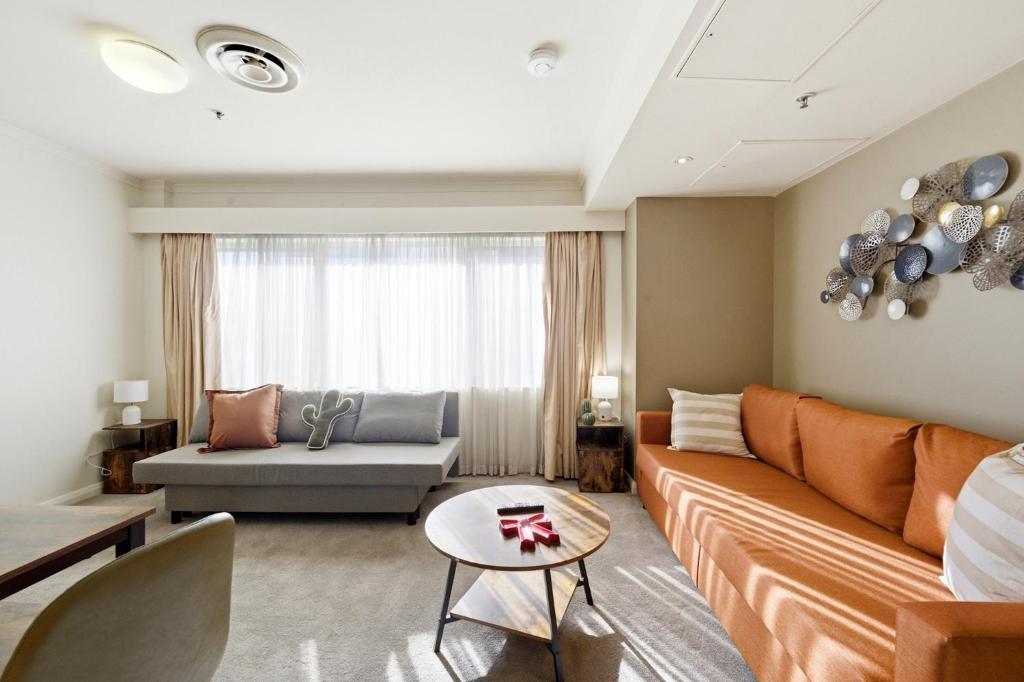 a living room with a couch and a table at Stylish 2-Bed Stay with Pool & Parking in Canberra