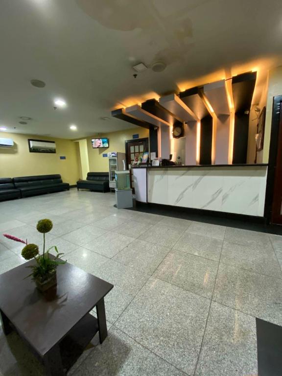a lobby with a waiting room with a table and a counter at Nice Hotel Arayat Cubao in Manila