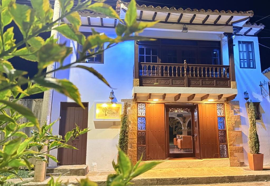 a house with a balcony on the side of it at Hotel Villa Encanto in Villa de Leyva