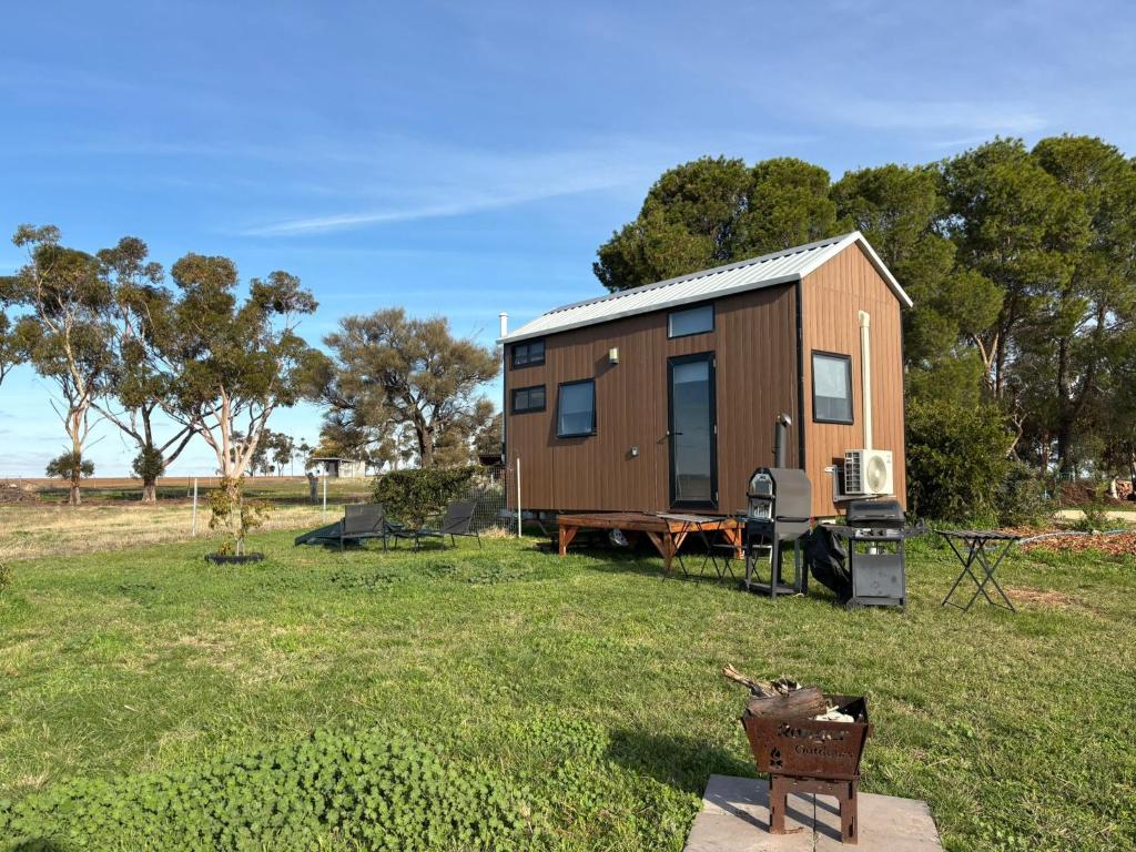 a tiny house in a field with a grill at Loft Tiny House by Tiny Away in Banyena