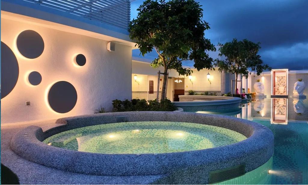 a house with a large circular pool in the yard at Stallionz Ipoh by ANGO in Ipoh