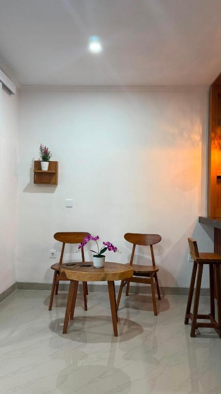 two benches and a table in a room at Rdm Bali Guest House in Badung