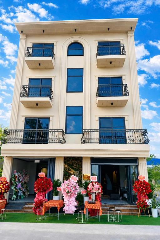 a building with chairs and flowers in front of it at Dragon King Hotel Nghệ An in Cửa Lô