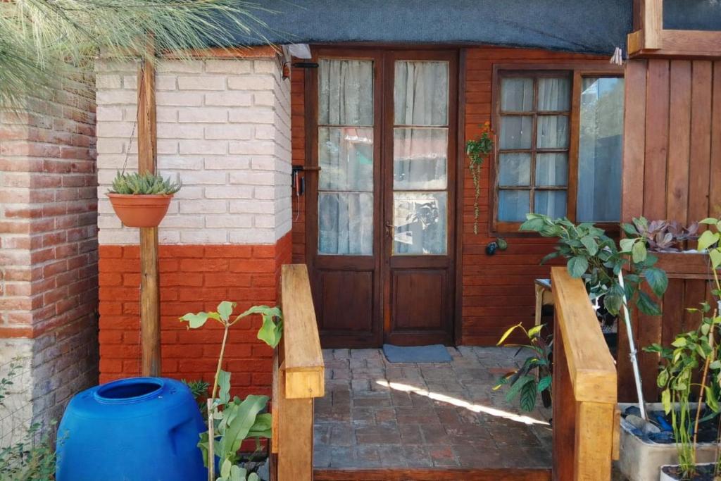 a house with a wooden door with a potted plant at Gather in Balneario Argentino