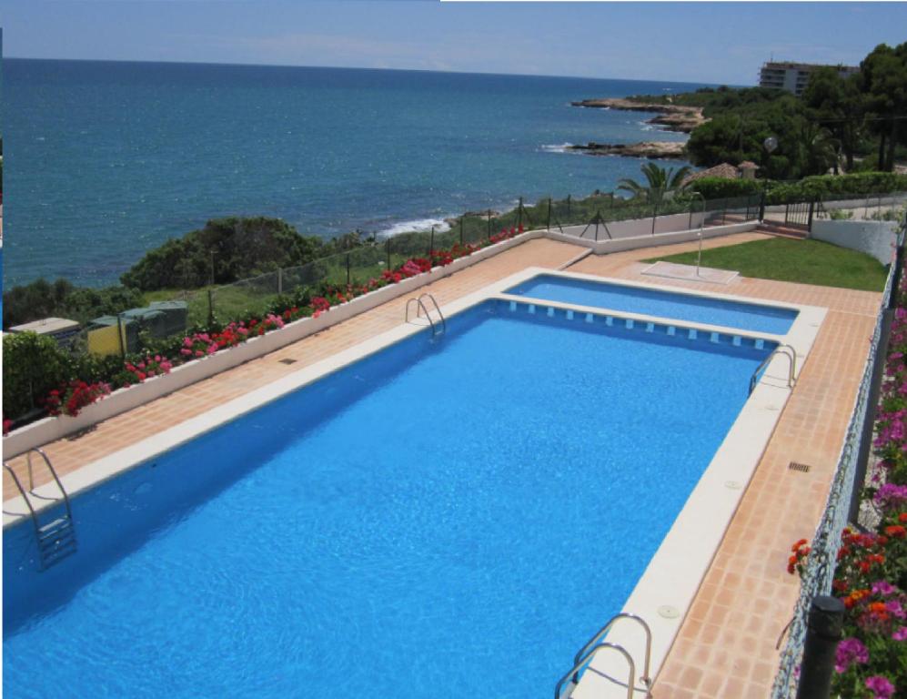 a swimming pool with the ocean in the background at Apartamentos Rayos de Sol in Peniscola
