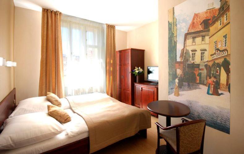 a bedroom with a bed and a table and a window at U Stare Pani - At the Old Lady Hotel in Prague