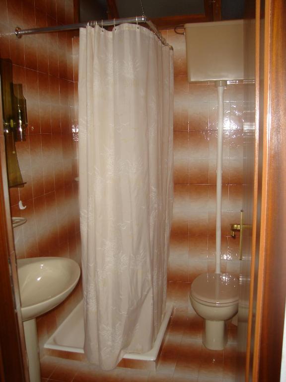 a bathroom with a white shower curtain and a toilet at VILLA Apartments Mate Cebalo in Lumbarda