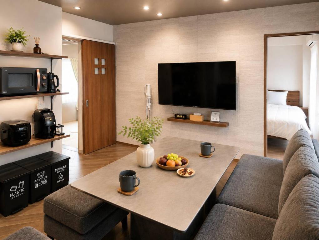 a living room with a couch and a table with fruit on it at WinGoodDays in Kumamoto