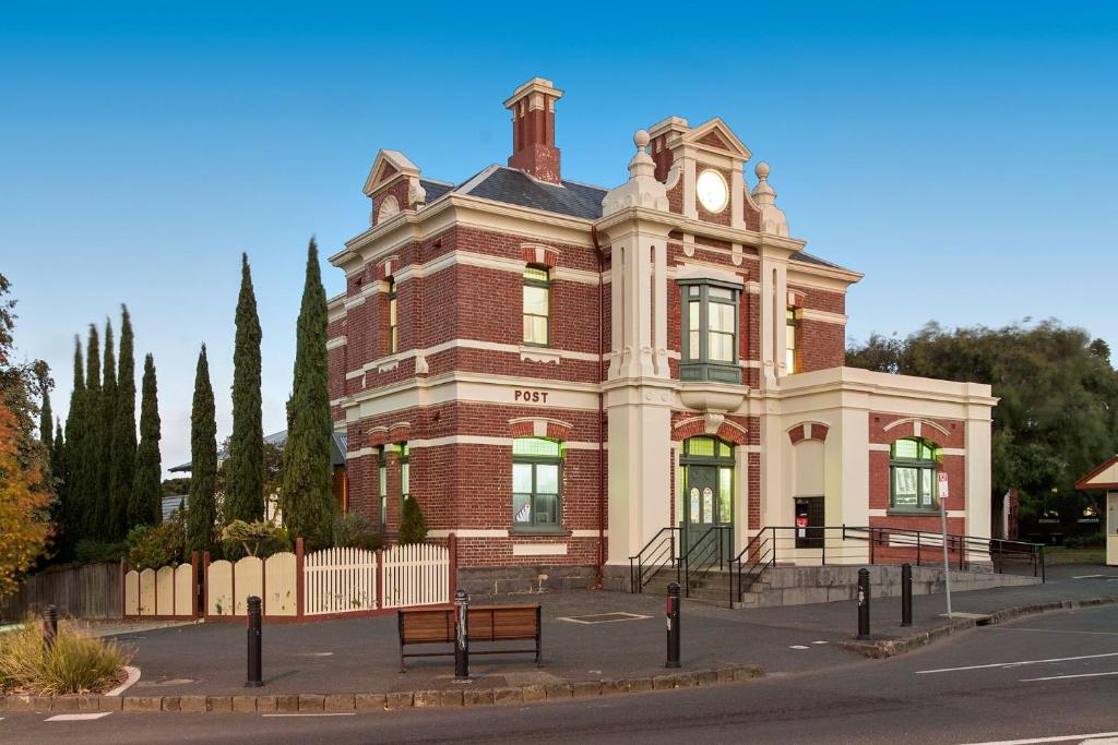 a large brick building with a clock on it at QPO Queenscliff in Queenscliff