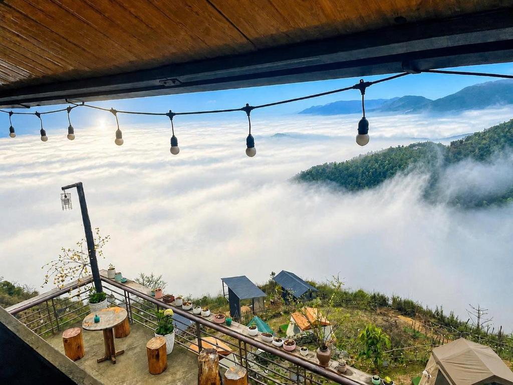 a room with a view of a foggy mountain with lights at Xìu Homestay Tà Xùa in Bắc Yên