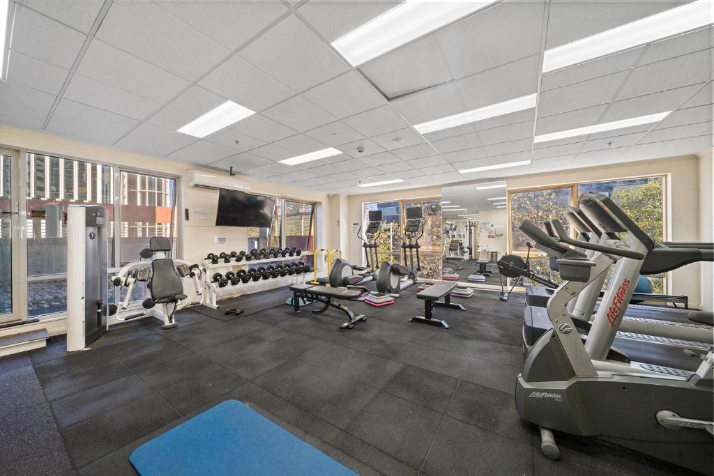 a gym with treadmills and machines in a room at City-Edge 1-Bed Apartment with Pool Access in Canberra