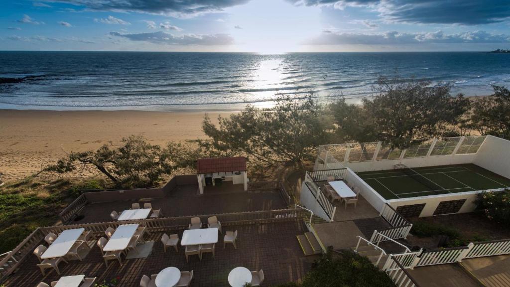 an aerial view of a house with a tennis court and the beach at Don Pancho Beach Resort in Bargara