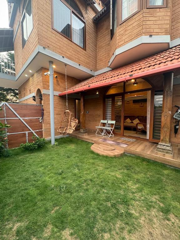 a house with a patio and a yard at Prakruthi Hill View 3BHK Entire Villa in Nandi
