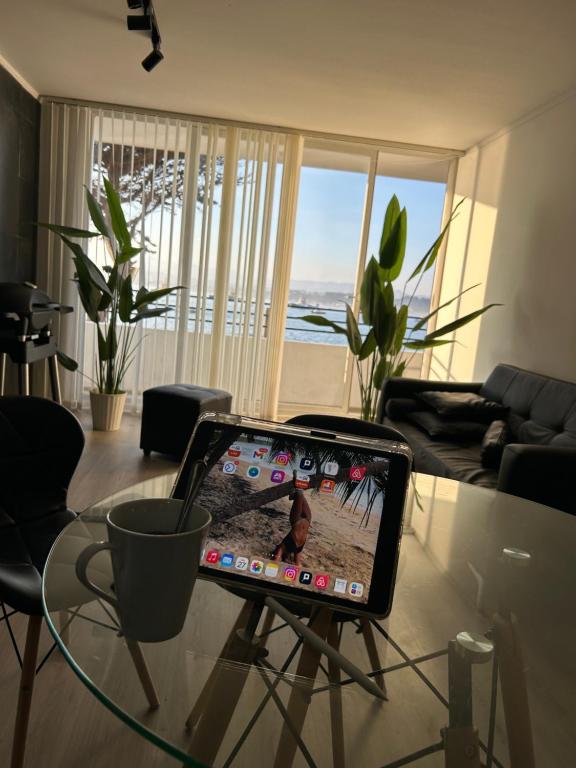 a laptop sitting on a glass table in a living room at Costa del mar in Quintero