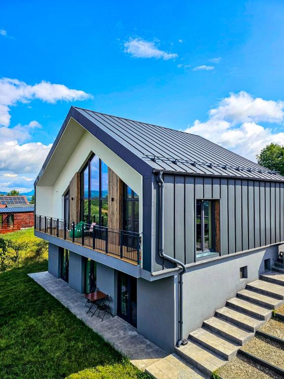 a small house with a balcony on a lawn at Bran Villa - A-frame Orchard Hygge in Bran