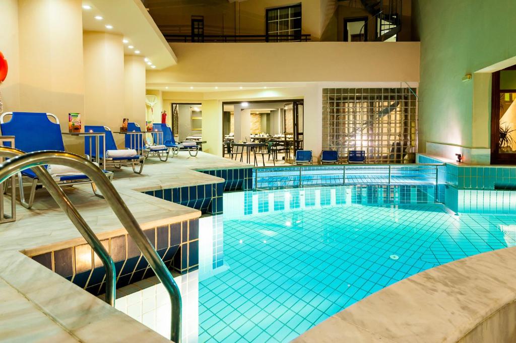 una piscina con azulejos azules en una habitación de hotel en Elina Hotel Apartments en Rethymno