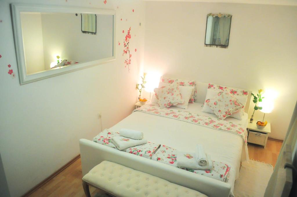 ein Schlafzimmer mit einem Bett mit einem Spiegel und einem Stuhl in der Unterkunft Apartment Premsai in Rovinj