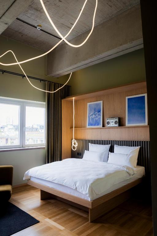 a bedroom with a large white bed and a chandelier at ALPAMI Boutique Glockenbach in Munich