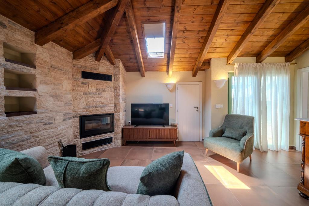 a living room with a couch and a television at Leon Suites Nemea in Neméa