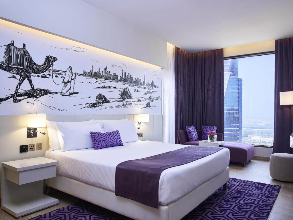 Ein Schlafzimmer mit einem Kingsize-Bett und einem auf die Wand gezeichneten Kamel. in der Unterkunft Mercure Dubai Barsha Heights Hotel Suites And Apartments in Dubai